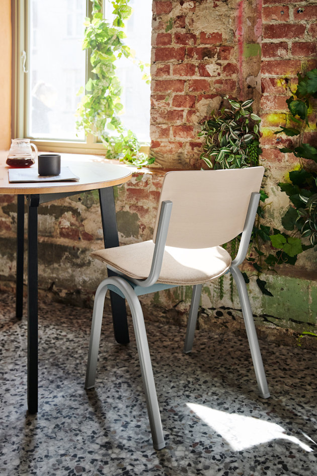 a table and chairs in front of a brick wall